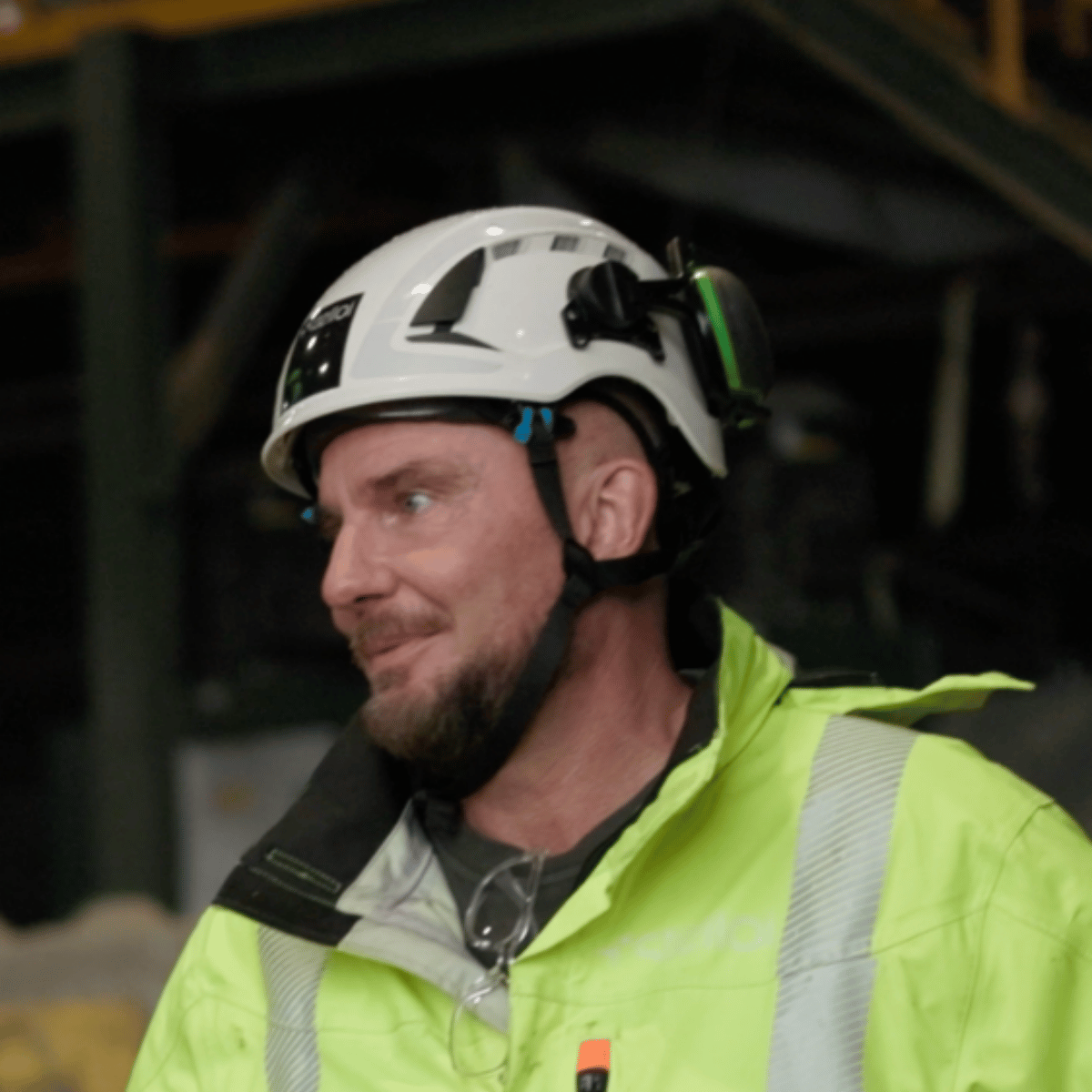 Mattias Sohl wearing a white safety helmet and high-visibility jacket at a recycling facility